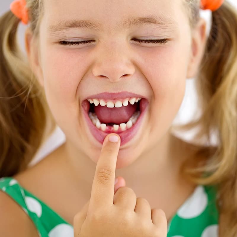 A smiling child showing her teeth