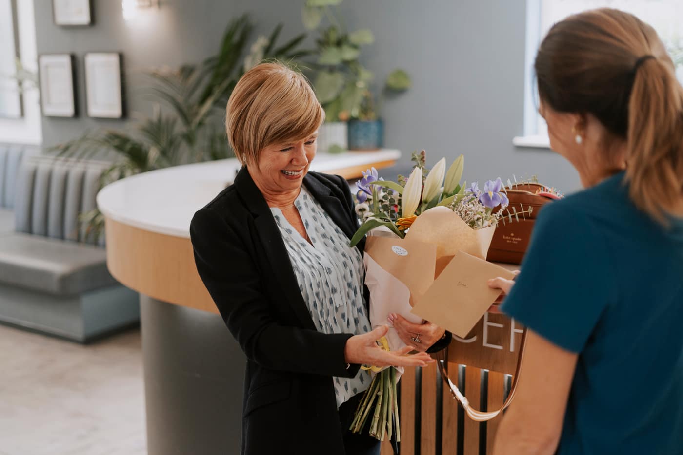 A happy patient bringing flowers to the team